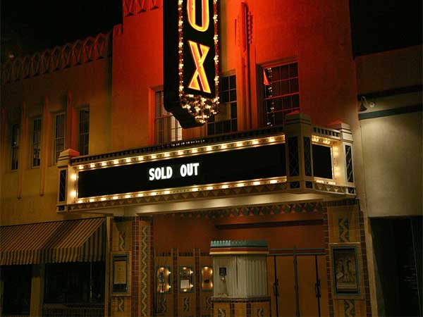 The outside of a theatre with lights around a black sign that says sold out. Text below says Drama for drama instruction.